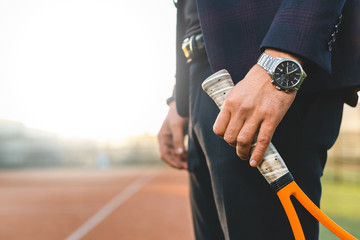 Businessman hand holding tennis racket 