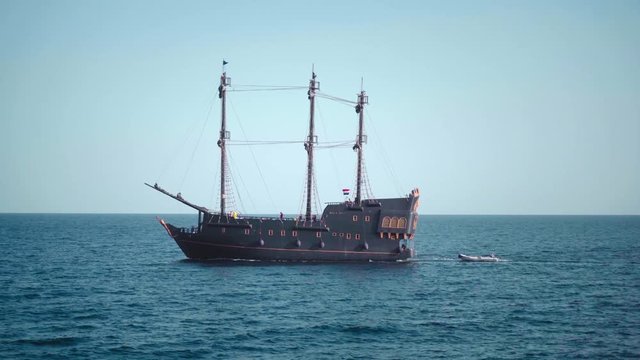 A pirate sailboat in the blue waters of the ocean.