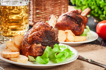 Roasted turkey knuckle with fried potato slices