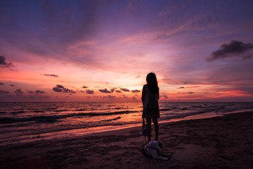 Fototapeta na wymiar Silhouette of Asian girl on the beach on sunset