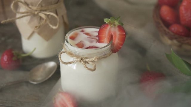 Organic yogurt with strawberries in a glass jar.