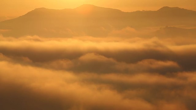 mountains in beautiful clouds with mist and morning sunrise