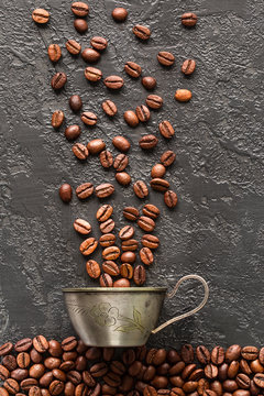 coffee beans and mug on gray concrete background.