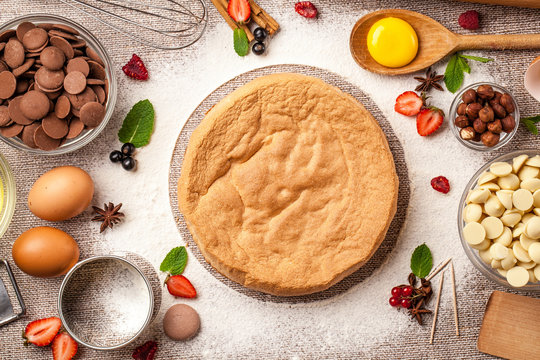 Concept of cooking pies, cakes, pastries and biscuits. Confectionery stock lies on a table, corolla, eggs, white, milk, black chocolate, flour and berries, strawberries, mint, with text space