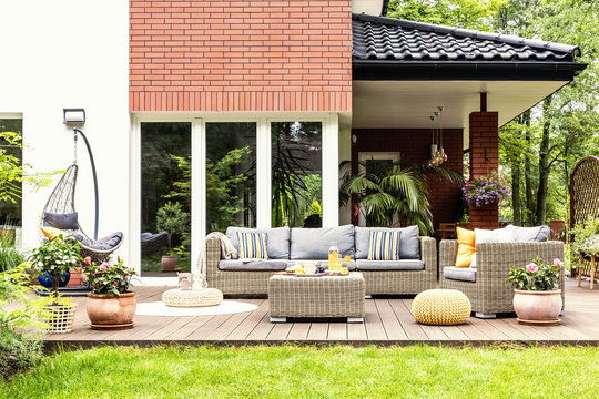 Real photo of a beautiful terrace with garden furniture, plants and swing