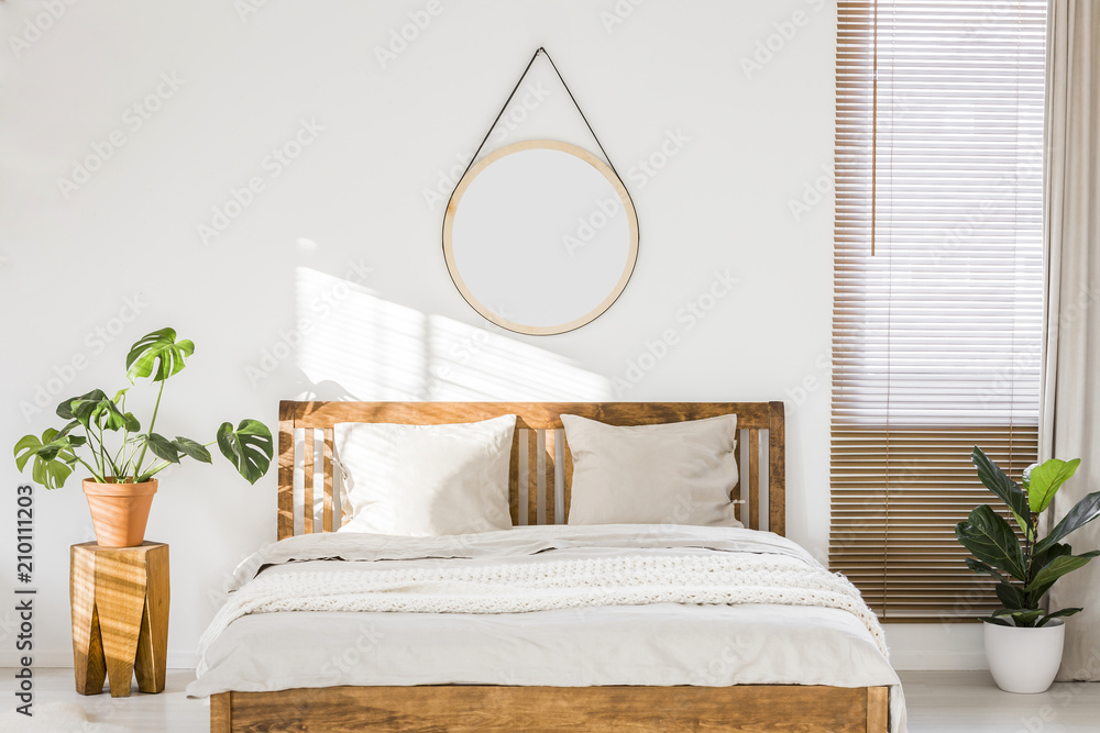 Wall mural sun shining on a white wall with a round mirror in a minimalist bedroom interior with natural, woode - Wall murals