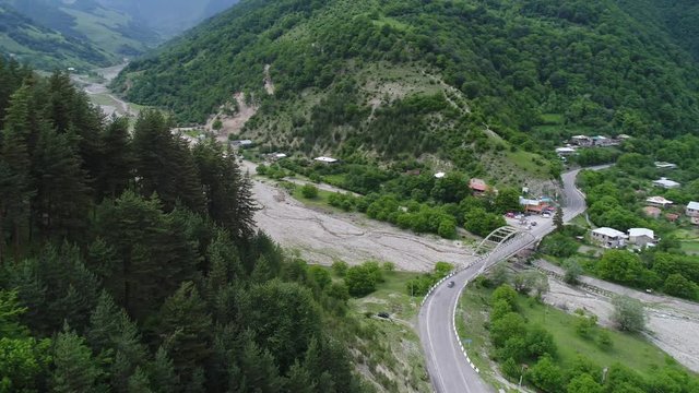 Aerial view. Road bridge across the river in the depths of a picturesque mountain gorge. Concrete bridge on the Georgian military road in bottom of a beautiful canyon.