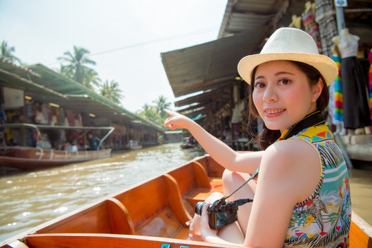 Woman sitting on a boat in floating market.