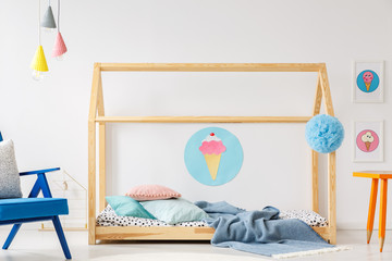Ice cream poster on the wall in modern colorful bedroom interior with wooden DIY bed