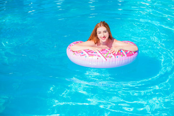 Woman relaxing on donut lilo in the pool water in hot sunny day. Summer holiday idyllic. Enjoying...