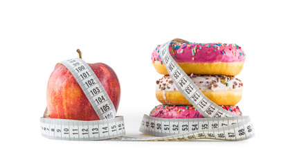 Red apple and three colorful donuts wrapped in a tailors measuring tape.