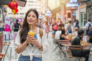woman holding a cup of mango juice
