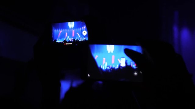 Fan spectator hands hold shoot phone video on a music concert staying in crowd