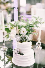 Elegant white wedding cake with flowers, blueberries and succulents