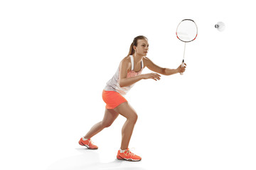 Young woman playing badminton over white background