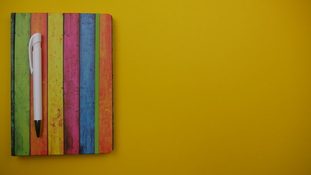 geschlossenes Notizbuch auf einen gelben Hintergrund