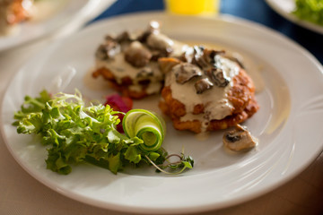 meat with mushrooms and salad. garnish on a white plate. food, lunch