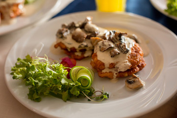 meat with mushrooms and salad. garnish on a white plate. food, lunch