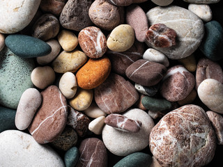 Gas-colored sea pebbles on a gray granite background