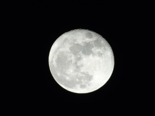 An amazing photography of the full moonlight under a dark sky with some small stars in the background