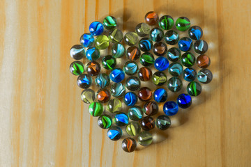 Group of heart shaped marbles on a wooden background