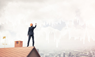 Man architect draw silhouette of modern city on blue sky. Mixed 