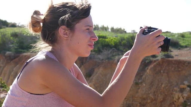 Young woman tourist takes pictures with photo camera traveling to Malta