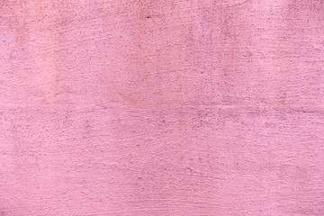 Uneven concrete wall painted in different colors as a background