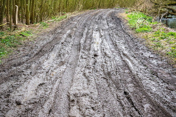 Muddy trail with tire tracks next to River Cole in England