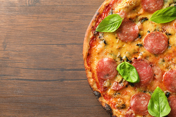 Tasty pepperoni pizza on wooden table, top view