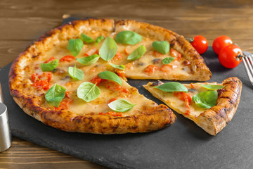 Slate plate with delicious pizza Margherita on table