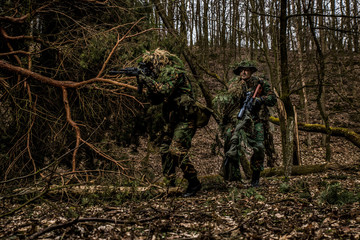 Sniper team during patrol in the dark forest
