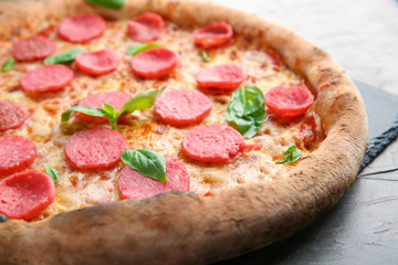 Slate plate with delicious pizza on table, closeup