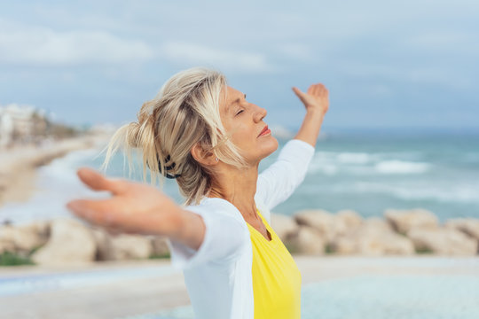 Woman standing on a beach meditating