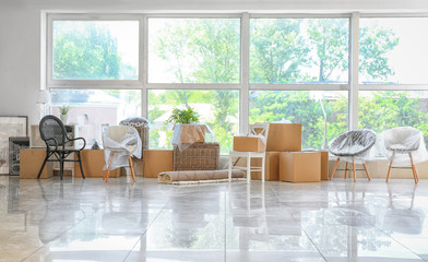 Carton boxes and interior items on floor in room. Moving house concept