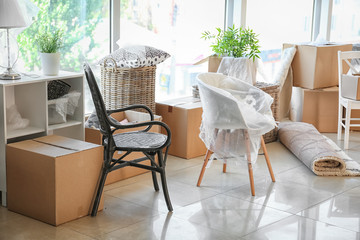 Carton boxes and interior items on floor in room. Moving house concept