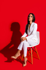 Photoshooting studio concept. Vertical portrait of proud arrogant woman sitting on chair leg by...