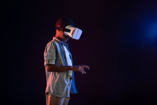 Challenge accepted. Content afro-american boy wearing a VR headset and typing on a keyboard