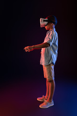 Difficult game. Pleased afro-american boy wearing a VR headset and typing on a keyboard