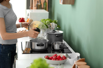 Young woman cooking in kitchen