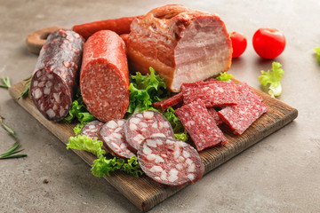 Assortment of delicious deli meats on wooden board