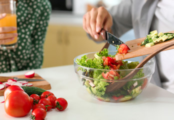 Young man cooking with his girlfriend in kitchen