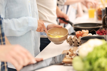 Young woman cooking with friends in kitchen