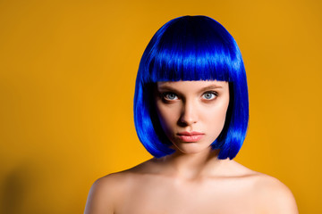 Head shot portrait of serious confident woman in blue wig isolated on yellow background. Barber...