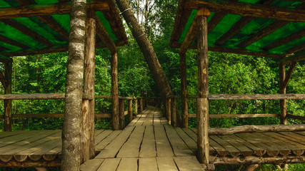 Fototapeta na wymiar Wooden bridge across river in Russia