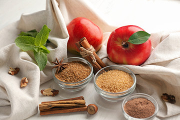 Obraz na płótnie Canvas Cinnamon, sugar and fresh apples on table