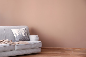 Fototapeta na wymiar Comfortable sofa near color wall in living room