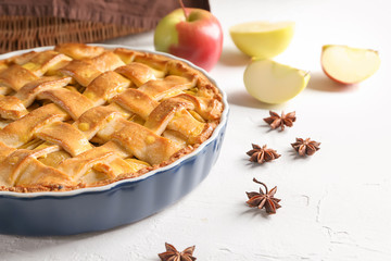 Dish with delicious apple pie on table