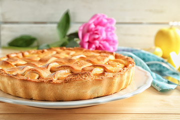 Plate with delicious apple pie on wooden table