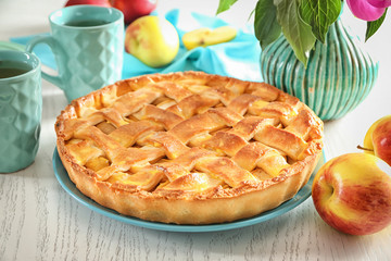Plate with delicious apple pie on wooden background
